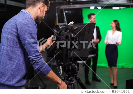 Presenters and video camera operator working in studio. News broadcasting Presenters and video camera operator working in studio. News broadcasting 95641961