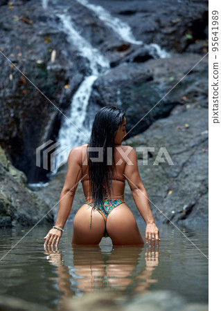 Beautiful woman posing at small tropical waterfall 95641989