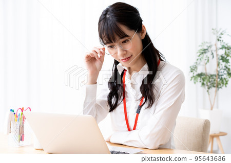 Young woman in eyeglasses using laptop in office 95643686