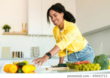Healthy food to boost your immune system. Young african american woman cooking fresh salad at home in kitchen Healthy food to boost your immune system. Young african american woman cooking fresh salad at home in kitchen 95643713