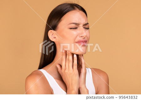 Cold symptoms and medicine concept. Portrait of sick woman suffering from sore throat, ill lady touching neck with hands Cold symptoms and medicine concept. Portrait of sick woman suffering from sore throat, ill lady touching neck with hands 95643832