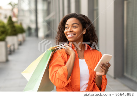 Online shopping, huge sale. Happy millennial african american female in casual with many shopping bags Online shopping, huge sale. Happy millennial african american female in casual with many shopping bags 95643998