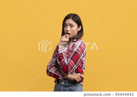 Oh no. Portrait of chinese lady touching mouth with hand and looking at camera, emotionally reacting to bad news Oh no. Portrait of chinese lady touching mouth with hand and looking at camera, emotionally reacting to bad news 95644042
