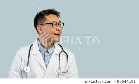 Smiling surprised middle aged chinese man doctor in white coat, glasses looks at empty space 95644191