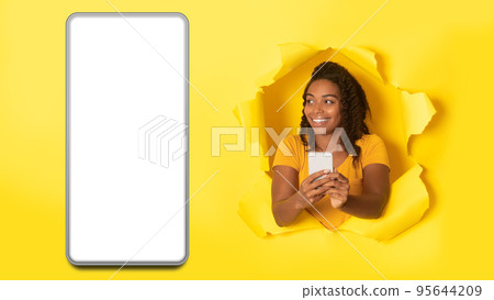 African Woman Using Phone Posing Near Large Smartphone Screen, Studio African Woman Using Phone Posing Near Large Smartphone Screen, Studio 95644209