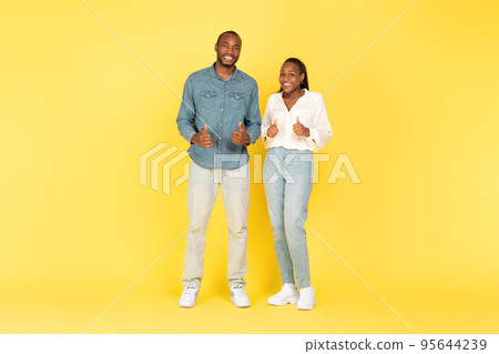 Black Couple Gesturing Thumbs Up Approving Offer On Blue Background Black Couple Gesturing Thumbs Up Approving Offer On Blue Background 95644239