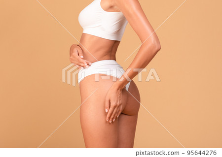 Unrecognizable young fit woman in white underwear showing smooth silky skin on her sexy buttocks, cropped Unrecognizable young fit woman in white underwear showing smooth silky skin on her sexy buttocks, cropped 95644276