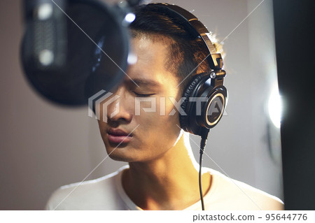 young asian musician singer singing song in recording studio 95644776