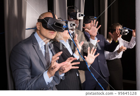 Frightened business people in vr glasses Frightened business people in vr glasses 95645128