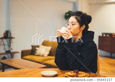 一個女人在一個房間裡喝咖啡 95645157