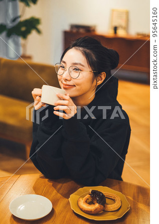 一個女人在一個房間裡喝咖啡 95645160