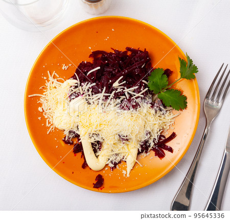 Grated boiled beets with cheese and mayonnaise, parsley on yellow plate Grated boiled beets with cheese and mayonnaise, parsley on yellow plate 95645336