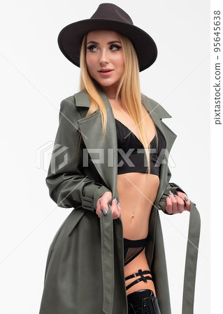 Sensual young lady in lingerie and coat looking at camera in studio 95645638