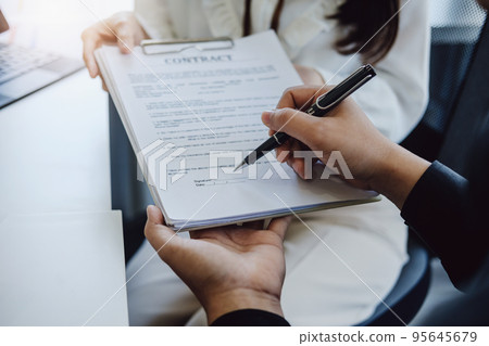 Guarantee, Mortgage, agreement, contract, Signing, Male client holding pen to reading agreement document to sign land loan with real estate agent or bank officer 95645679