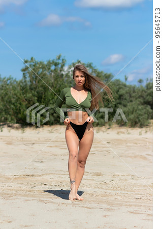 Attractive woman standing on seashore 95645713