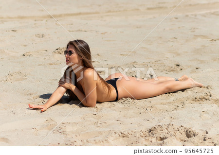 Topless woman lying on beach Topless woman lying on beach 95645725