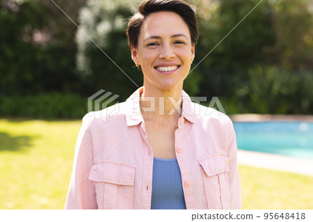 Portrait of young caucasian women wearing blue shirt and standing in the garden 95648418