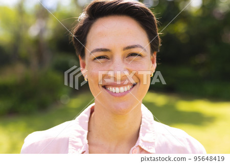 Portrait of young caucasian women wearing blue shirt and standing in the garden 95648419