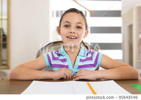 Happy caucasian girl learning and taking notes in notebook in living room 95648546