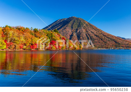 View of Mt. Nantai from Nikko Chuzenji Lake dyed in autumn leaves 95650238