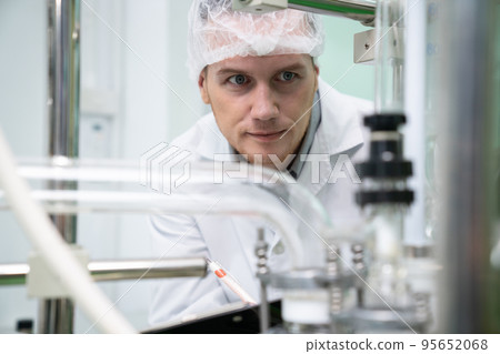 Portrait of a scientist, apothecary extracting cannabis oil in laboratory. 95652068