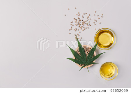 Legalized marijuana concept CBD oil in glass bowl and bottle with dropper lid. Legalized marijuana concept CBD oil in glass bowl and bottle with dropper lid. 95652069