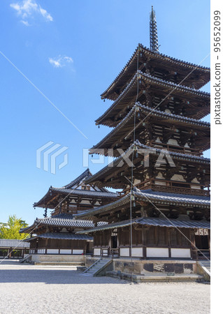 Five-storied pagoda and Kondo (Saiin Garan, Horyuji Temple) shining against the blue sky 95652099