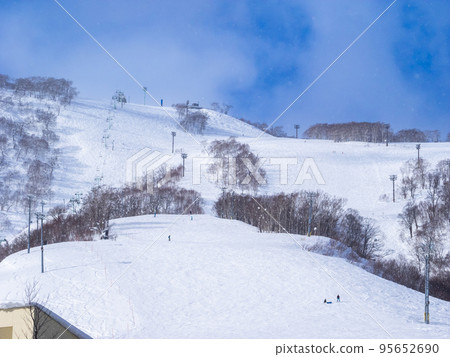A quiet slope where snow falls against the blue sky (Hokkaido, Niseko) 95652690