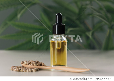 Legalized CBD oil extracted from marijuana in a glass bottle with a dropper lid. Legalized CBD oil extracted from marijuana in a glass bottle with a dropper lid. 95653658
