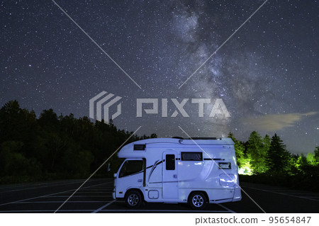 A camper with the rising Milky Way in the background A camper with the rising Milky Way in the background 95654847