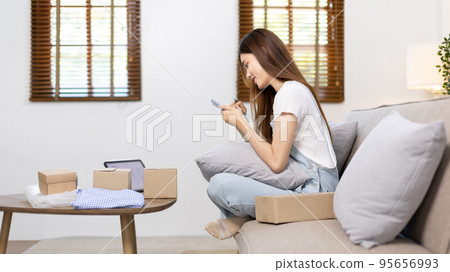 Woman uses mobile phone or tablet to chat with customers who come to order product, Freelance work at home, Conversation with customers through massage, Small business owner, SME entrepreneur. 95656993