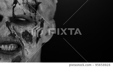Zombie man face makeup with wounds scars and white contact lenses blood flows and drips on face 95658928