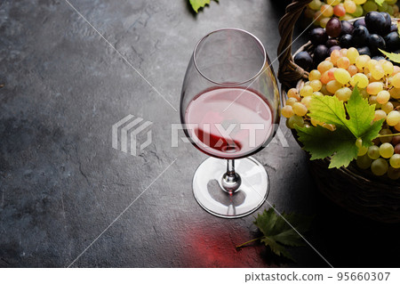 Red wine in glass, bottle and grapes in basket Red wine in glass, bottle and grapes in basket 95660307