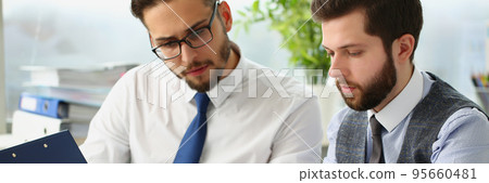 Coworkers men go through financial papers, solve and discuss problems Coworkers men go through financial papers, solve and discuss problems 95660481