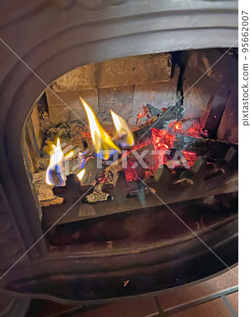 Firewood in a burning wood stove 95662007