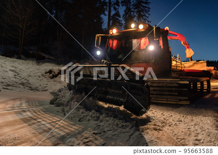 Snowcat ratrack machine making snow at ski resort. Snow grooming at night Snowcat ratrack machine making snow at ski resort. Snow grooming at night 95663588
