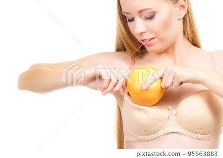 Woman small boobs puts big fruit in her bra Woman small boobs puts big fruit in her bra 95663883