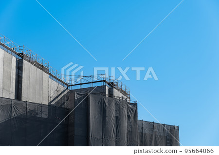 Scaffolding and protective sheets at a construction site Scaffolding and protective sheets at a construction site 95664066