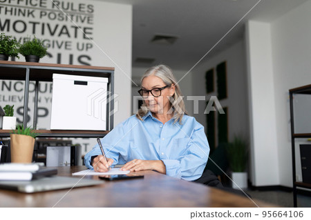 Middle aged older business woman of European appearance works as a manager in the office, concept of 95664106