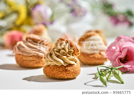 tasty cake shu or eclairs with cream on white background with copy space tasty cake shu or eclairs with cream on white background with copy space 95665775