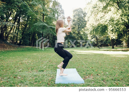 Young girl doing yoga exercise in the park.. Young girl doing yoga exercise in the park.. 95666553