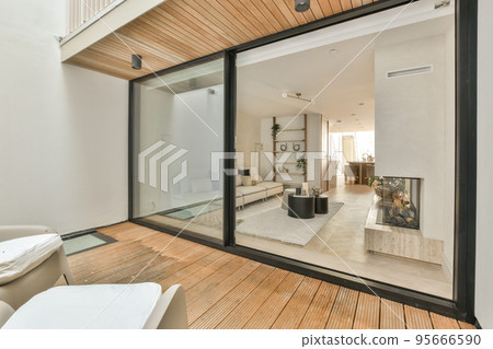 Large soft velvet couch with colorful cushions in living room with wooden parquet and kitchen island under ceiling with beams Large soft velvet couch with colorful cushions in living room with wooden parquet and kitchen island under ceiling with beams 95666590