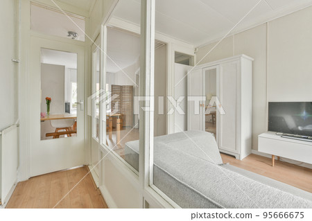 Comfortable sofa with cushions placed against light wall with TV and decorations in modern loving room 95666675