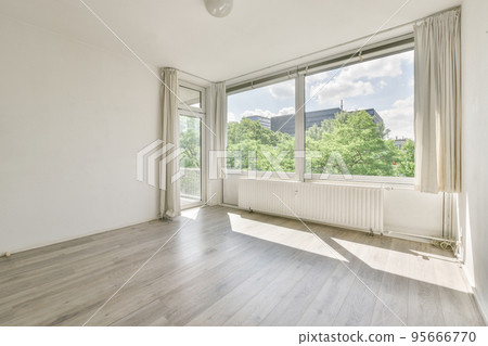 Plastic window and radiator on white wall in empty light room at home 95666770