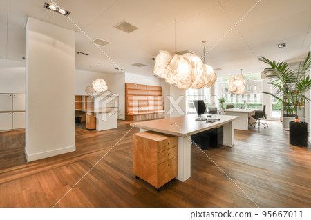 Table with chairs and flowers located near lounge area and kitchen in spacious room of contemporary apartment Table with chairs and flowers located near lounge area and kitchen in spacious room of contemporary apartment 95667011