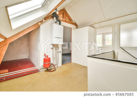 Boiler room of an apartment building with pipes and metering devices. A long room with engineering communications in the modern apartment Boiler room of an apartment building with pipes and metering devices. A long room with engineering communications in the modern apartment 95667085