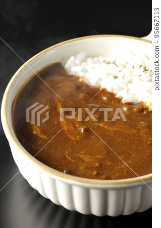 在黑色背景下拍攝了放在耐熱板上的熱奶酪咖哩飯 95667113