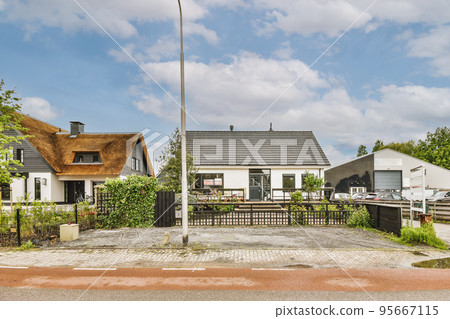 The front view of a brick building with signs,pavement and wooden doors lead to the apartment 95667115