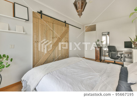 Bed with colorful pillows and blanket located near glass wall of restroom in modern apartment Bed with colorful pillows and blanket located near glass wall of restroom in modern apartment 95667195