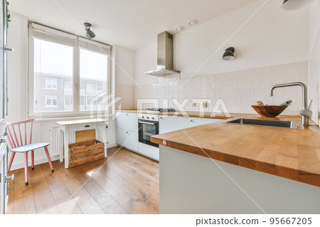 Corner cupboards and table with chairs located in light kitchen of contemporary flat Corner cupboards and table with chairs located in light kitchen of contemporary flat 95667205